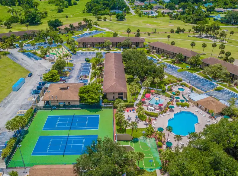 Aerial view of a Lehigh Acres community with a pool, tennis courts and golf course, an area served by our appliance repair technicians