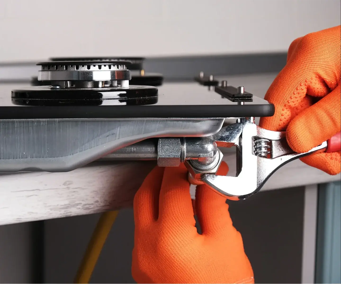 Technician showing a homeowner a dishwasher repair in her kitchen